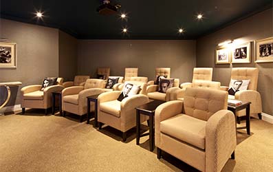 Two rows of comfy armchairs in the Cinema Room at Beaumont Manor