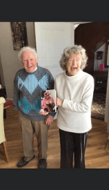 Jean and James on their 70th Wedding Anniversary with their card from the Queen