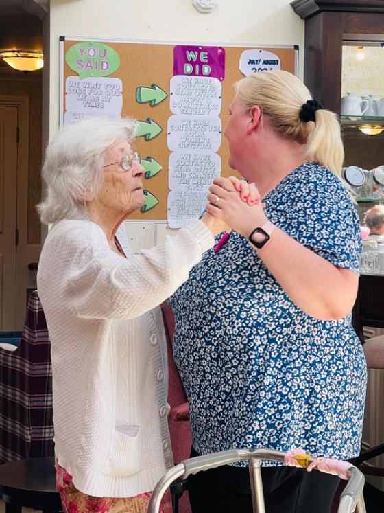 resident dancing with staff