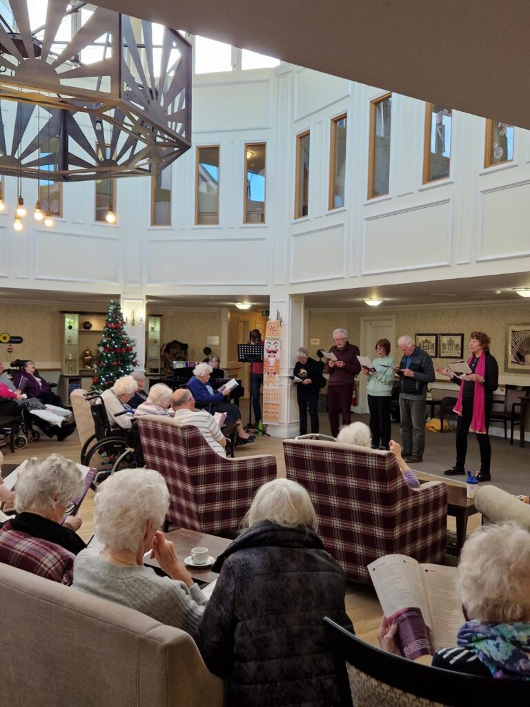 residents watching visitors doing christmas carolling