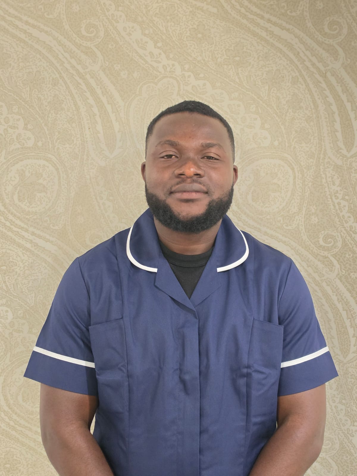 man in nurse uniform smiling for staff photo
