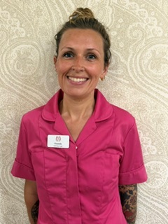 lady in pink shirt smiling at camera for staff photo