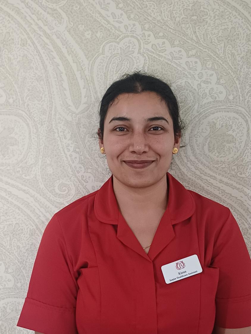 lady in red shirt smiling at camera for staff photo